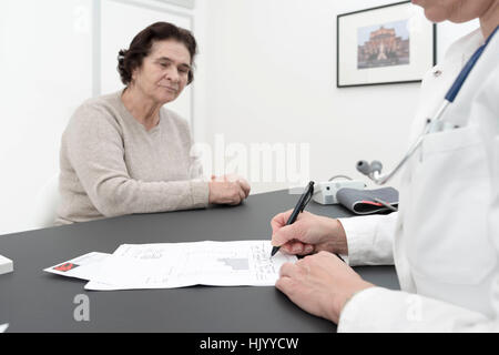 Arzt Beratung senior weiblichen Patienten-Kardiologe erklärt ECG Ergebnisse senior Patientin Stockfoto