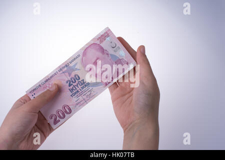 Hand hält Turksh Lira Banknote auf weißem Hintergrund Stockfoto