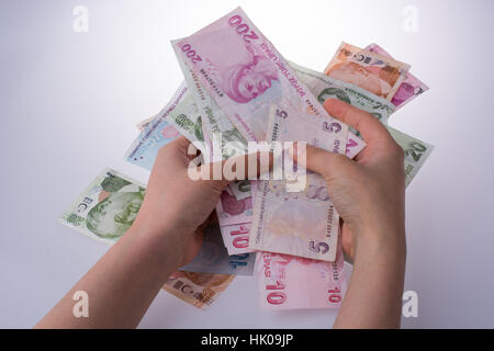 Hand hält Turksh Lira-Banknoten auf weißem Hintergrund Stockfoto