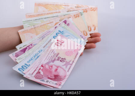 Hand hält Turksh Lira-Banknoten auf weißem Hintergrund Stockfoto