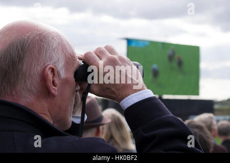 Mann mit dem Fernglas beobachten Pferderennen Stockfoto