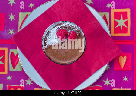 Dekadente hausgemachte Schokolade-Mousse mit frischen Himbeeren auf einer roten Serviette Stockfoto