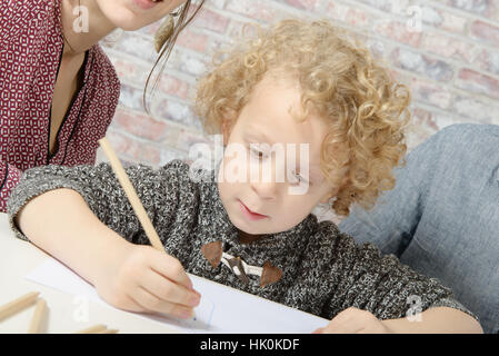 kleinen lockigen Blondschopf Zeichnung mit seinen Eltern Stockfoto