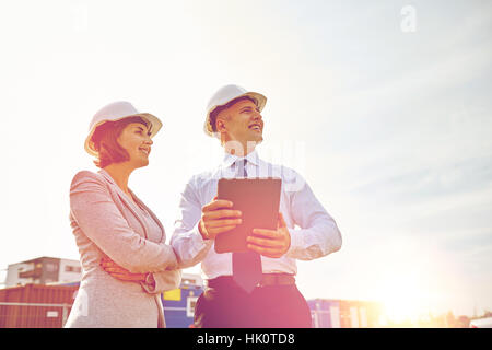 glückliche Bauherren in Schutzhelme mit Tablet-pc im freien Stockfoto