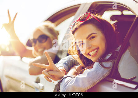 glückliche Mädchen oder Frauen im Auto am Meer Stockfoto