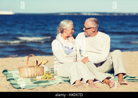 gerne älteres Paar mit Picknick am Sommerstrand Stockfoto