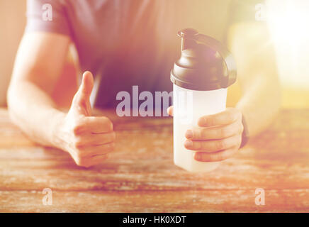 Mann mit Protein shake Flasche Daumen auftauchen Stockfoto