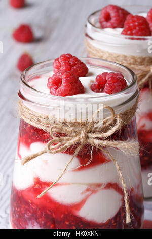 frische Himbeeren Joghurt in ein Glas Glas Nahaufnahme auf vertikale Tabelle Stockfoto