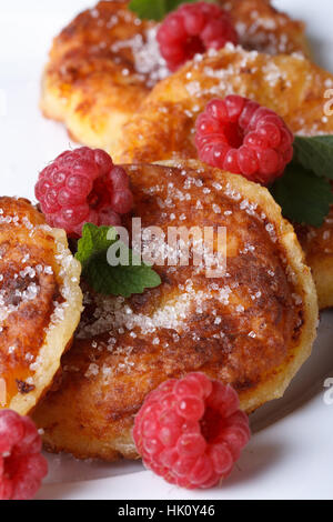 Leckere Käse-Pfannkuchen mit Himbeeren und Minze auf einem weißen Teller Closeup. vertikale Stockfoto