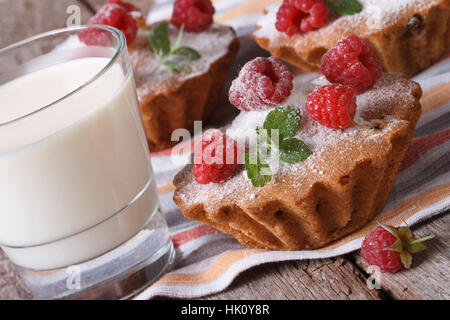 Frische Muffins mit Himbeeren Closeup und Milch in ein Glas auf einem Holztisch horizontale Stockfoto