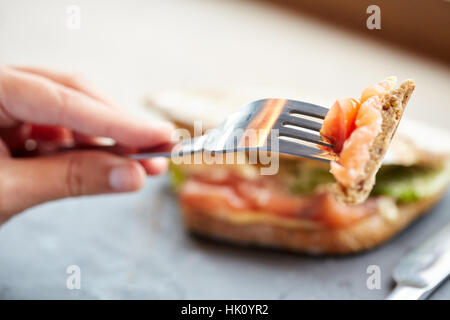 Frau essen Lachs Panini Sandwich Restaurant Stockfoto