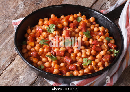 Kichererbsen mit Chorizo in einer Pfanne Nahaufnahme und mit den Zutaten auf der horizontalen Tischplatte anzeigen Stockfoto