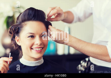 glückliche Frau mit Stylist Frisur im Salon machen Stockfoto