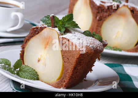 Scheibe der Birne Torte mit Minze Closeup auf einem weißen Teller auf einem Holztisch horizontale Stockfoto