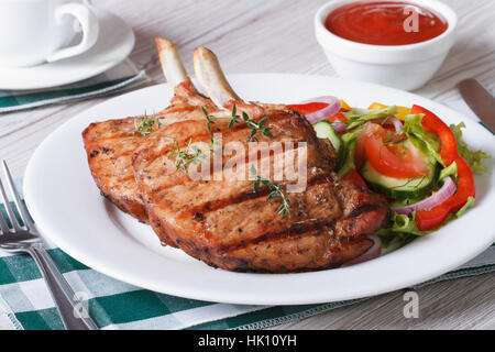 Schweinefleisch gegrillt mit Salat aus frischem Gemüse auf einem weißen Teller. horizontale hautnah Stockfoto