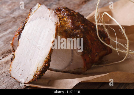 In Scheiben geschnitten gebackenes Schweinefleisch Filet Closeup auf Papier auf dem Tisch. horizontale Stockfoto