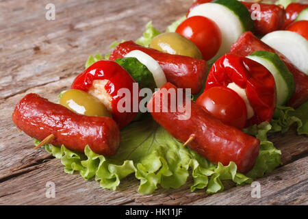 Bratwurst mit frischem Gemüse auf Spieße auf einem alten Tisch Closeup horizontale Stockfoto