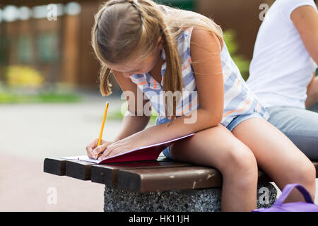 Studentin schreiben an Notebook am Schulhof