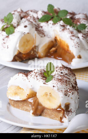 Bananen-Kuchen mit Sahne und Minze hautnah auf dem Tisch. vertikale Stockfoto