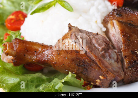 Gebratene Entenkeule auf einem Hintergrund von Reis und Gemüse Makro horizontale Stockfoto