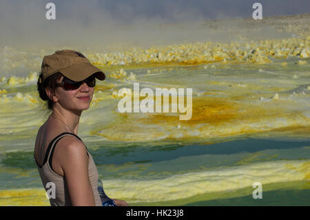 Frau in Hut und Sonnenbrille auf Dalol, Danakil-Senke, Äthiopien und lebendige gelb und grün die seltsame Kristallformen Stockfoto