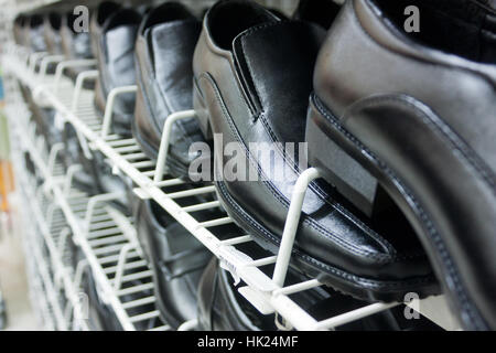 Schwarze Lederschuhe in Regalen In perspektivischer Darstellung Stockfoto