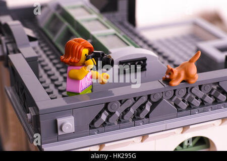 Tambow, Russische Föderation - 21. Januar 2017 Lego Mädchen mit Kamera stehend auf dem Dach und nehmen Foto der Katze auf dem Geländer. Studio gedreht. Stockfoto