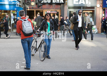 LONDON, UK - 27. August 2016: Smiley Mädchen in einem grünen T-shirt beim Überqueren der Straße mit dem Fahrrad Stockfoto