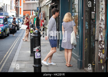 LONDON, ENGLAND - 12. Juli 2016 Mädchen in einem gestreiften Kleid und ein Junge in einem gestreiften T-shirt steht nahe dem Speicher betrachten Schaufenster Stockfoto