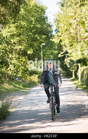 Alter Mann mit Fahrradhelm mit dem Fahrrad. Sommer Lifestyle Moment mit aktiven älteren Menschen ein gesundes Leben. Stockfoto