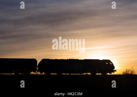 Klasse 68 Diesellok ziehen Chiltern Railways Mainline Zug, Silhouette bei Sonnenuntergang, Warwickshire, UK Stockfoto