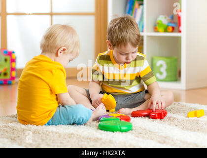 Kinder der kleine Junge spielt mit einem Multi-farbigen Puzzle im Kindergarten Stockfoto