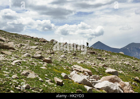 entfernte Frau Wandern auf einem Bergkamm in den San Juan Mountains von Colorado Stockfoto