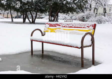 Eine Bank in einem schneebedeckten Park. Bratislava, Slowakei. Stockfoto