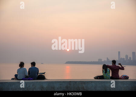 Paare beobachten den Sonnenuntergang über Chowpaty Beach in Mumbai (Bombay), Indien. Stockfoto