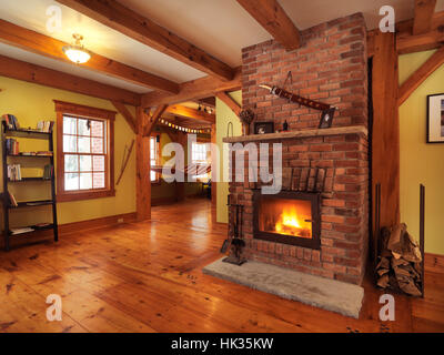 Brennender Kamin in einem Timberframe kanadische Land Haus Wohnzimmer Interieur, Muskoka, Ontario, Kanada Stockfoto