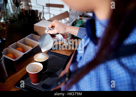 Barkeeper, gießt Barista Kaffee in einer Tasse Cappuccino Cafebar Stockfoto
