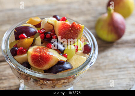 Joghurt, Müsli und frisches Obst in eine Schüssel geben Stockfoto