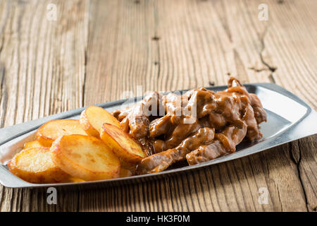 Boeuf Stroganoff, Originalrezept von russischen Gericht. Dünne Streifen von Rindfleisch in saurer Sahne und Tomatenmark, serviert mit knackigen Kartoffeln gekocht Stockfoto