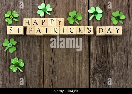 Glücklich St. Patricks Tag Holzblöcke mit handgeschöpftem Papier Kleeblätter über einen rustikalen hölzernen Hintergrund Stockfoto