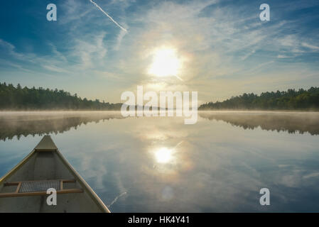 Kanutour am Morgen.  Brillante und leuchtende Mitte Sonnenschein Sommermorgen, eine Kanu mitten im ruhigen, ruhige und friedliche Corry See paddeln. Stockfoto