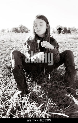 Mädchen sitzen auf dem Rasen Stockfoto