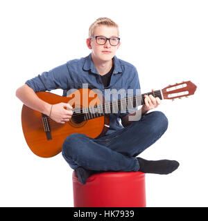 Kaukasische teenboy in blau trägt eine Brille und spielt die klassische Gitarre im Studio vor weißem Hintergrund Stockfoto