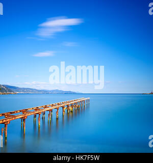 Hölzerne Pier oder Steg bleibt auf einem blauen Meer Sonnenuntergang. Ligurien, Italien. Lange Belichtung Fotografie Stockfoto