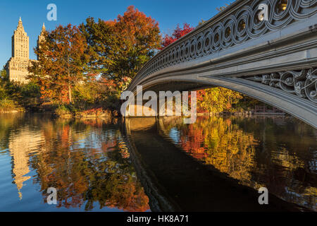 Fallen Sie im Central Park am See mit der Bogenbrücke. Morgendliche Aussicht mit bunten Herbstlaub auf der Upper West Side. Manhattan, New York City Stockfoto