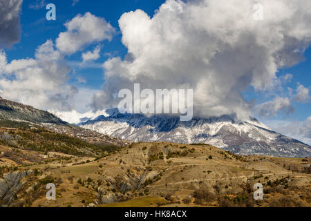 Schnee und Wolken mit Saint Apollinaire Dorf Mont Guillaume Berg bedeckt. Winter in den südlichen französischen Alpen. Hautes-Alpes, Fran Stockfoto