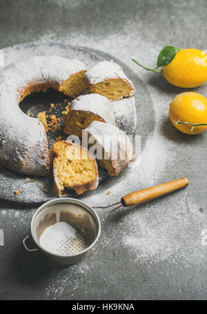 Hausgemachte glutenfreie Zitronen Gugelhupf mit Puderzucker über graue konkreten Hintergrund, selektiven Fokus Stockfoto