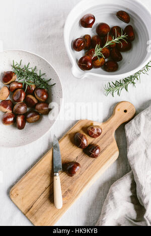 Kastanien sind geschnitten und in Wasser gelegt, bevor man bereit, geröstet werden. Stockfoto