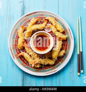 Frittierte, panierte Tempura Garnelen Garnelen mit Sauce auf blauem Hintergrund Stockfoto