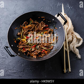 Wok-Pfanne auf dunklem Stein Braten Nudeln Yakisoba mit Rindfleisch und Gemüse einrühren Stockfoto